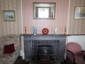 a living room with a fireplace and a chair at Spring Garden Guest House in Gosport