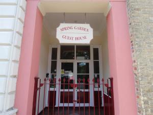 a pink building with a gate in front of a guest house at Spring Garden Guest House in Gosport