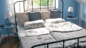 a bedroom with a bed with pillows and a window at Villa Idylla in Przesieka