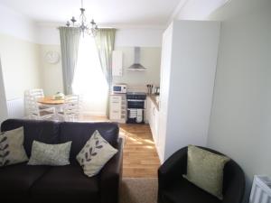a living room with a couch and a kitchen at Spring Garden Apartments in Gosport