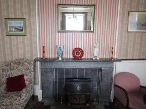- un salon avec une cheminée et une chaise dans l'établissement Spring Garden Apartments, à Gosport