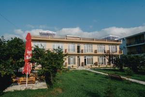 un edificio con un ombrello rosso davanti di sea-horizon a Kobuleti