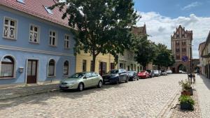 a cobblestone street with cars parked on the street at Blaue Perle Templin in Templin