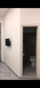 a white room with a toilet and a wall at Brighter's Room in Naples
