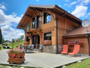 une cabane en rondins avec une terrasse, une table et des chaises dans l'établissement Chalet Elisa, à Le Valtin