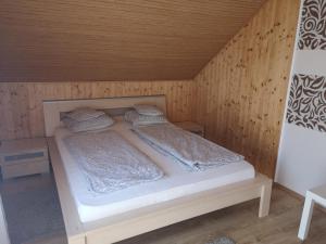 a bedroom with a bed in a wooden room at Relax Apartman in Balatonmáriafürdő