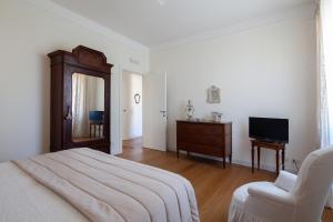 a bedroom with a bed and a chair and a television at La mia casa a Levante in La Spezia