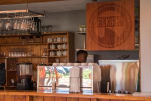 a man is standing behind a counter in a coffee shop at Harbour House Hotel - Manor House in Hermanus