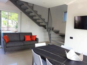 a living room with a black table and a couch at Villa Cisa in Lignano Sabbiadoro