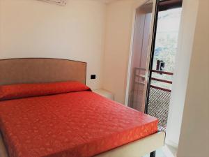 um quarto com uma cama vermelha e uma varanda em Villa Cisa con yacuzzi em Lignano Sabbiadoro