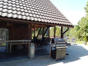 un patio con parrilla y mesa en Saunamaja koos tünnisaunaga, en Triigi