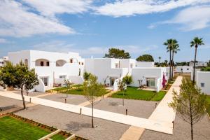 a view of a white house with trees in the foreground at Eques Petit Resort in Cala d´Or