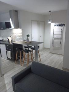 cocina y sala de estar con mesa y sillas en L'annexe, en Courseulles-sur-Mer