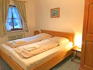 een slaapkamer met een houten bed en een raam bij Gschwendtnerhof App5 Pätzig in Aschau im Chiemgau