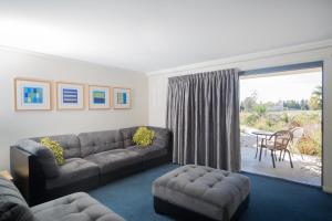 uma sala de estar com um sofá e uma mesa em Corrigans Cove em Batemans Bay