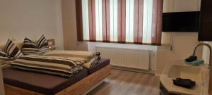 Cette chambre comprend un lit, un lavabo et une fenêtre. dans l'établissement Ferienwohnung Willi, à Schruns