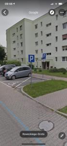 um parque de estacionamento com carros estacionados em frente a um edifício em Shutter Apartment em Gorzów Wielkopolski