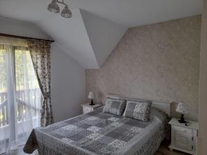 a bedroom with a bed and a window at Pensiunea Obcina Mare in Cacica