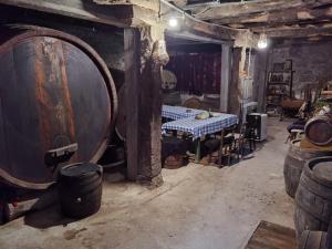 a wine cellar with a table and a large barrel at Konak -Guest house -Ramonda Serbika in Niš