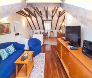 uma sala de estar com um sofá azul e uma televisão em Apartments Vi-La em Dubrovnik