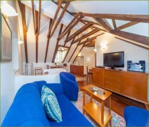 uma sala de estar com um sofá azul e uma televisão em Apartments Vi-La em Dubrovnik