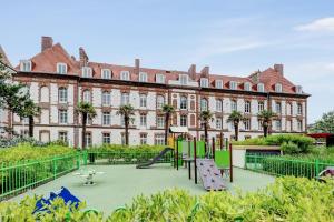 a playground in front of a large building at Résidence Pierre & Vacances Premium Presqu'Ile de la Touques in Deauville