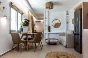Una sala de estar con una mesa y sillas y un sofá. en Apleton Suites, en Agia Anna de Naxos