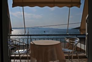 a table and chairs on a balcony with a view of the water at Delfini in Theológos