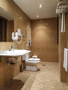a bathroom with a toilet a sink and a bathtub at Hotel Arcos Catedral in Ciudad-Rodrigo