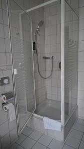 a bathroom with a shower and a bath tub at Hotel Landhaus Greene in Einbeck +26 photos