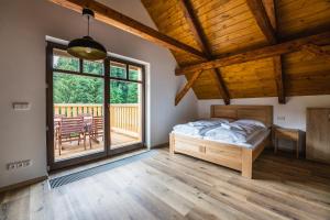 een slaapkamer met een bed en een groot raam bij Apartmány Mezivodí in Kyčera