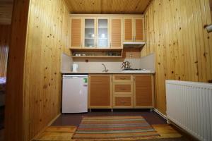 ウズンギョルにあるGünes Apartの木製の壁、白い冷蔵庫付きのキッチン