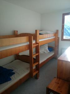 Zimmer mit 3 Etagenbetten und einem Fenster in der Unterkunft Les sybelles in La Chal