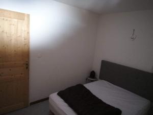 Habitación pequeña con cama y puerta en Les sybelles, en La Chal