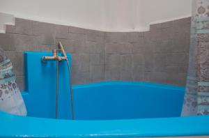 - une baignoire bleue dans une chambre dotée d'un mur en briques dans l'établissement Nino's house - in kato chorio of Ierapetra, à Káto Khoríon
