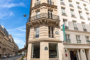 a tall white building with a clock tower on it at Hotel Touraine Opera in Paris