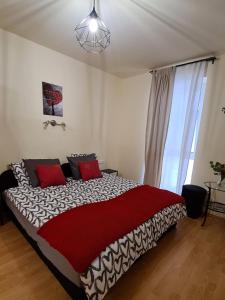 1 dormitorio con 1 cama grande con almohadas rojas en Lucsony Apartman en Mosonmagyaróvár