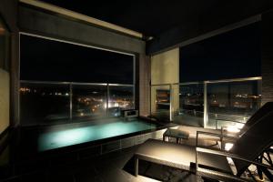 a swimming pool in a room with a balcony at night at Candeo Hotels Kameyama in Kameyama