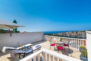 uma varanda com mesas e cadeiras e vista para o oceano em Apartment Lea em Dubrovnik