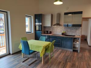 a kitchen with a green table and blue chairs at Ferienwohnungen Graßmann in Piding