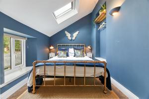 1 dormitorio con paredes azules y 1 cama en una habitación en Host & Stay - Percy Cottage, en Otterburn