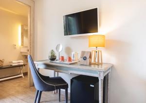 a desk in a hotel room with a lamp and a chair at 1935 Hotel Boutique by Terraza in Roses