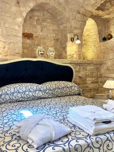 a bed in a room with a stone wall at Trulli e Puglia Luxury Suite in Alberobello