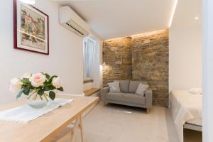 um quarto com uma mesa, uma cadeira e uma parede de pedra em Studio Apartment Tetida by Locap Group em Piran