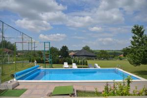 a large swimming pool with chairs and a ladder at Erida Guest House - къща за гости до Русе in Trastenik