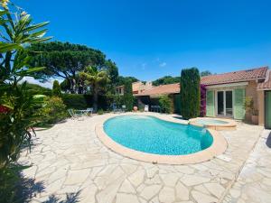 a backyard with a swimming pool and a house at villa avec jacuzzi in Sainte-Maxime