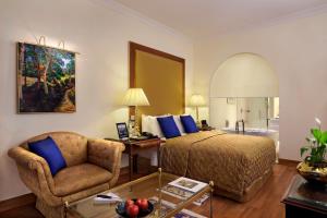 a hotel room with a bed and a chair at The Oberoi Bengaluru in Bengaluru