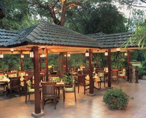 a restaurant with tables and chairs under a pavilion at The Oberoi Bengaluru in Bengaluru