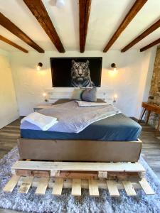 a bed with a picture of a tiger on the wall at Maisonette Eifel, mit Sauna und Whirlpool in Dahlem