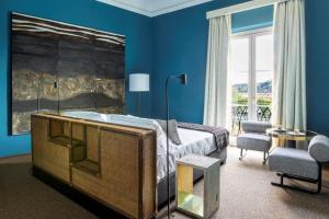 a blue bedroom with a bed and a chair at 4F Boutique Hotel Florence in Florence